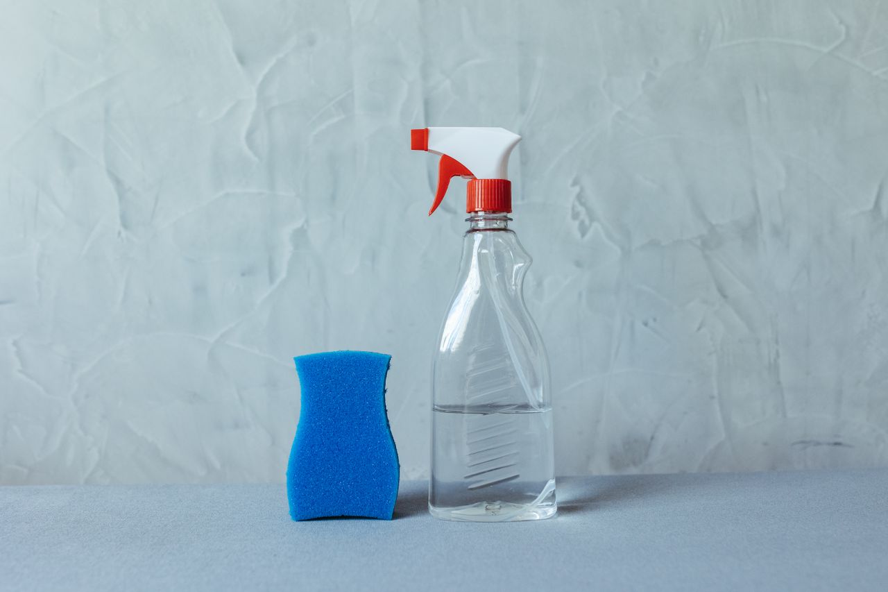 Mastering the First Impression: Your intriguing post title goes here A spray bottle and blue sponge on a textured grey surface. Perfect for cleaning themes.